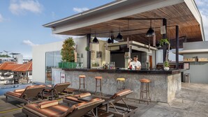 A rooftop bar with lounge chairs and a bartender. - Sevn Legian (Legian)