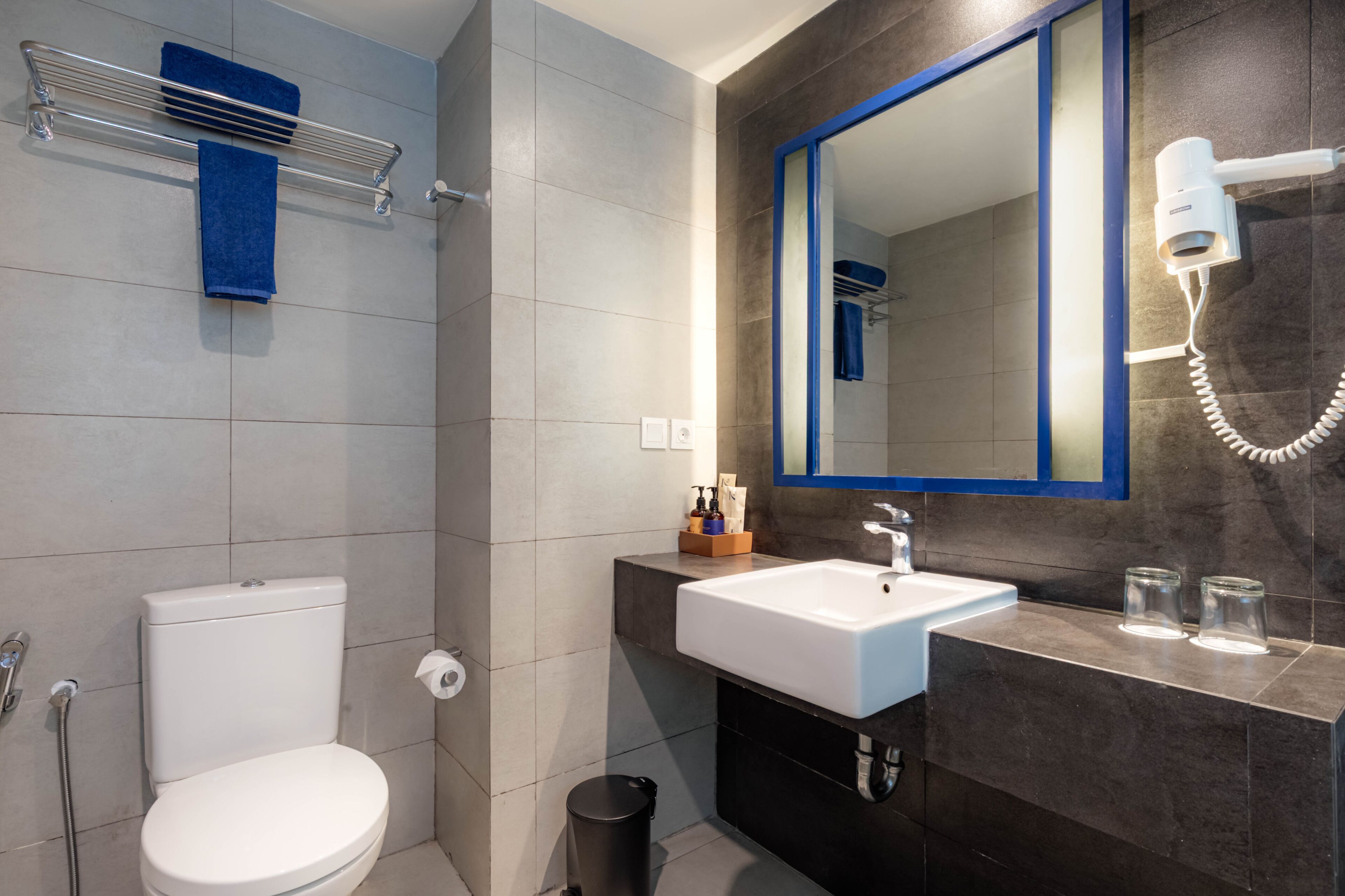 A modern bathroom with a toilet, sink, and mirror.