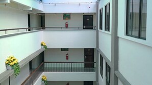 A multi-level atrium with a glass ceiling, balconies with railings, and potted plants. - Palace Hotel (Kuala Lumpur)