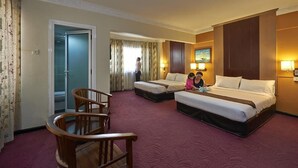 A hotel room with two beds, a wooden chair, a desk, and a television. - Palace Hotel (Kuala Lumpur)