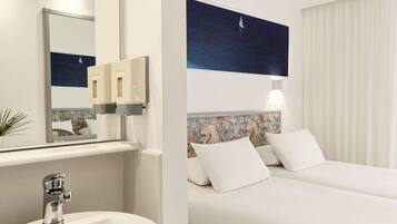 Habitación de hotel con una cama grande, una mesita de noche, un espejo, un lavabo y una lámpara fijada a la pared.