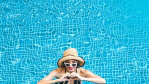 Una persona en una piscina con superficie de agua azul cristalina.