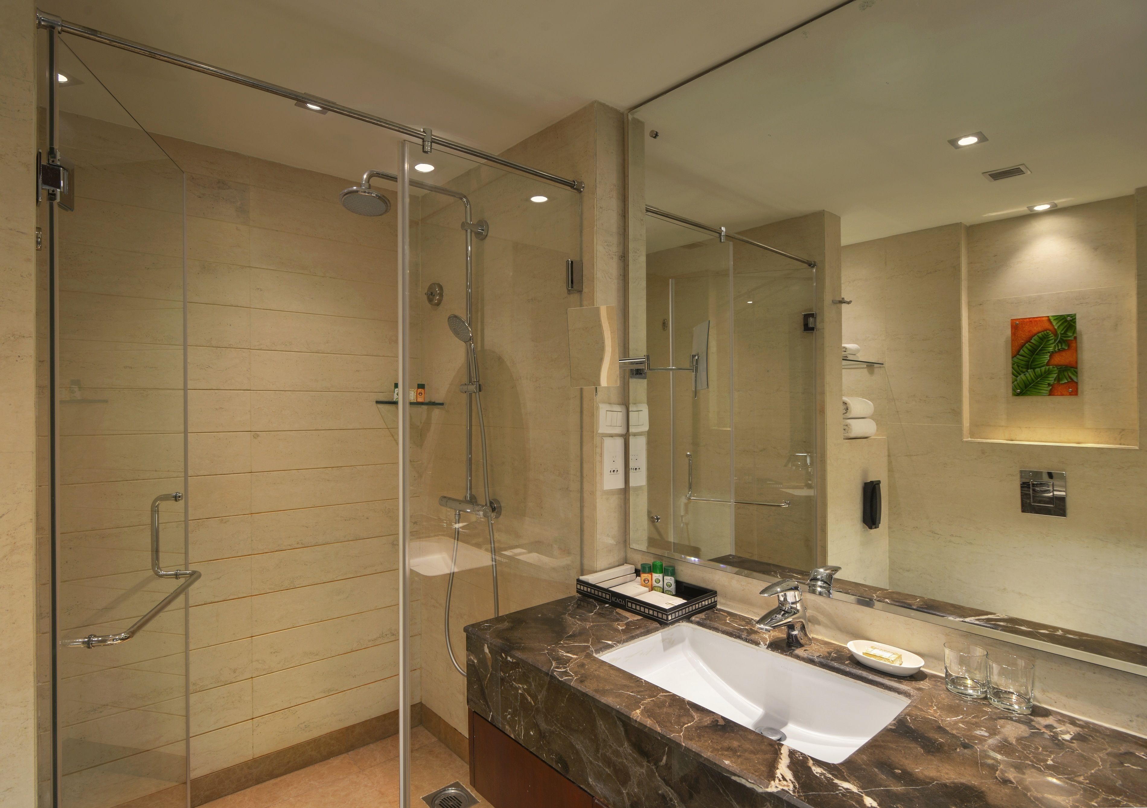 A modern bathroom with a glass-enclosed shower, a marble sink, and a large mirror.