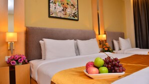 A hotel room with two beds, a fruit bowl on the bed, and a painting on the wall. - Metro Hotel (Kuala Lumpur)