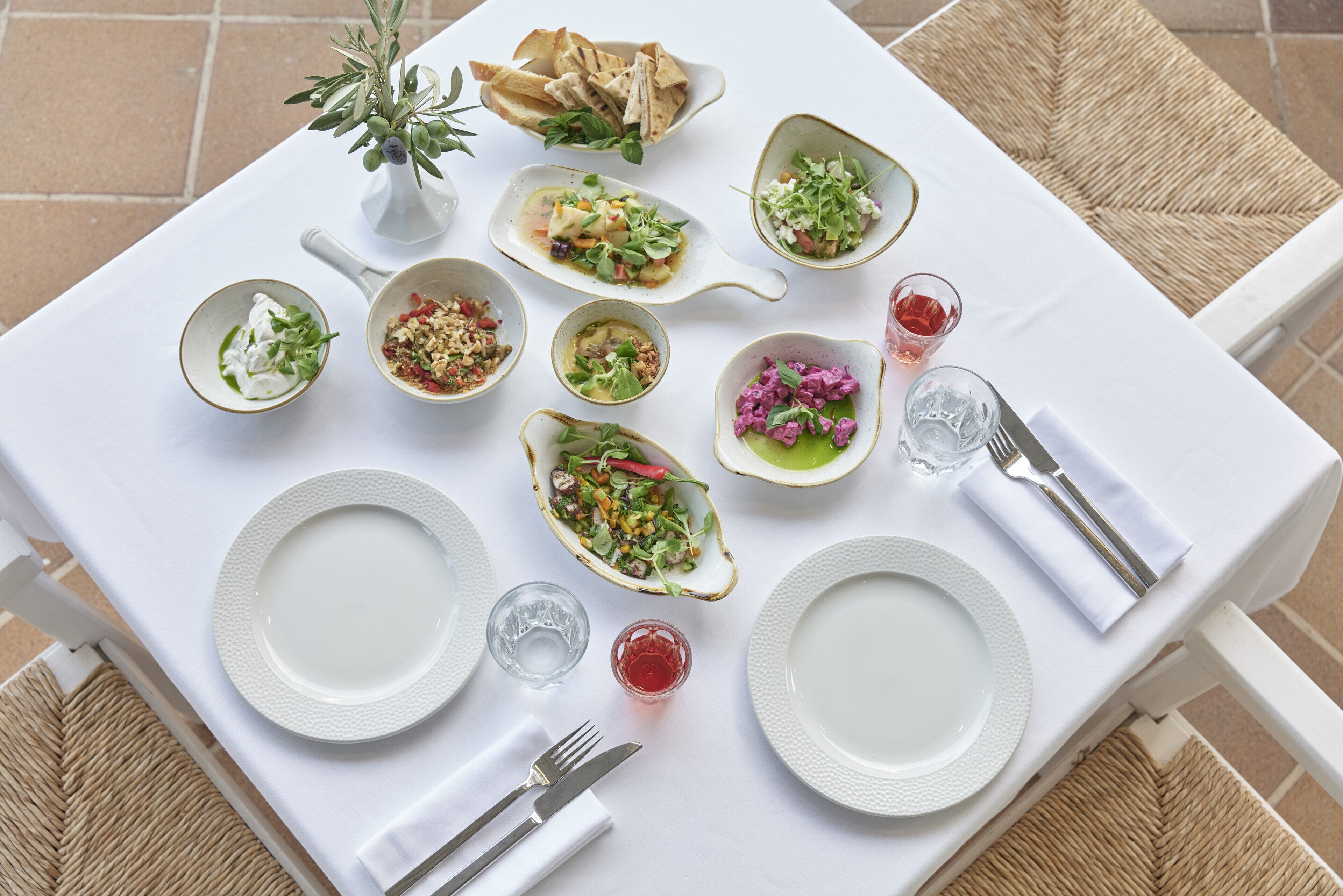 A dining table set with various dishes, plates, and cutlery.