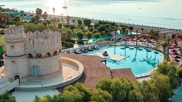 Una estructura tipo castillo con piscina y zona de playa.
