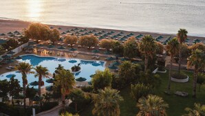 A resort with a pool, sun loungers, umbrellas, and palm trees. - Esperos Mare Resort & Spa (Rhodes)