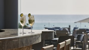 Two glasses of a beverage with lime garnish on a bar counter with a view of the sea. - Esperos Mare Resort & Spa (Rhodes)
