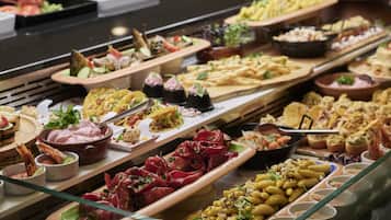 Un bufé con diversos platos, incluyendo mariscos, ensaladas y aperitivos.