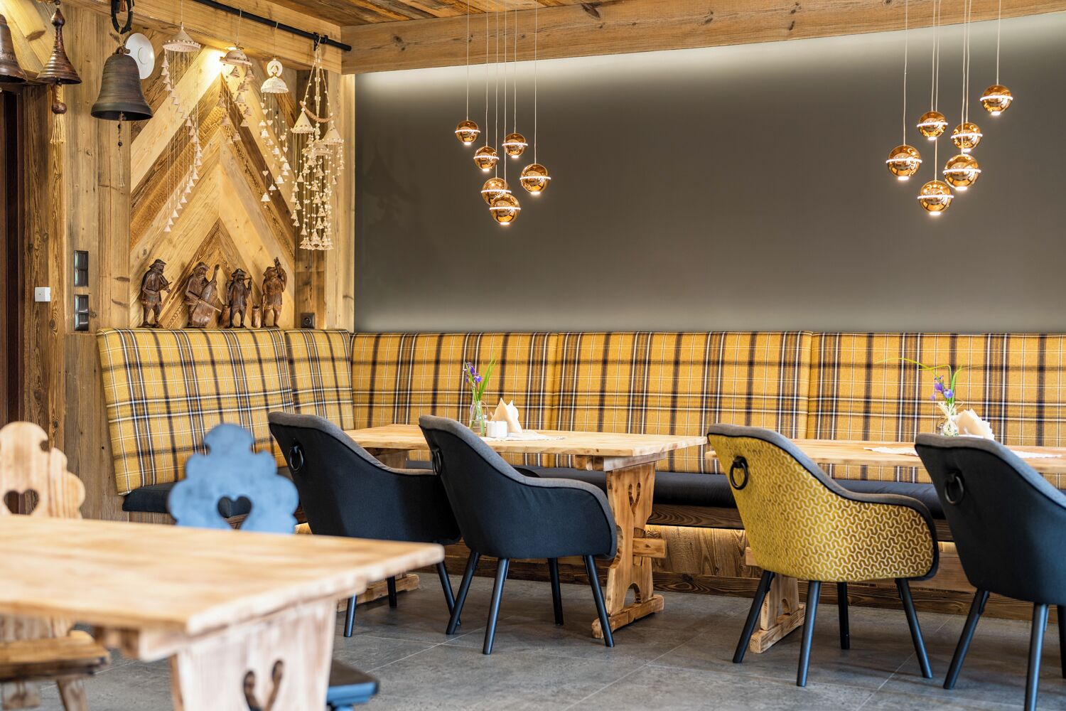 Un restaurante acogedor con paredes de madera, un banco a cuadros y sillas modernas.