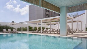 A modern pool area with clear water, lounge chairs, and a covered seating area. - Epsilon Hotel Apartments (Rhodes)