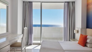 A hotel room with a large bed, a desk, and a view of the ocean. - Epsilon Hotel Apartments (Rhodes)