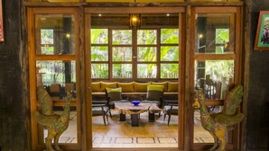 Una habitación con un banco de madera, una mesa de centro y dos estatuillas decorativas de pájaros.
