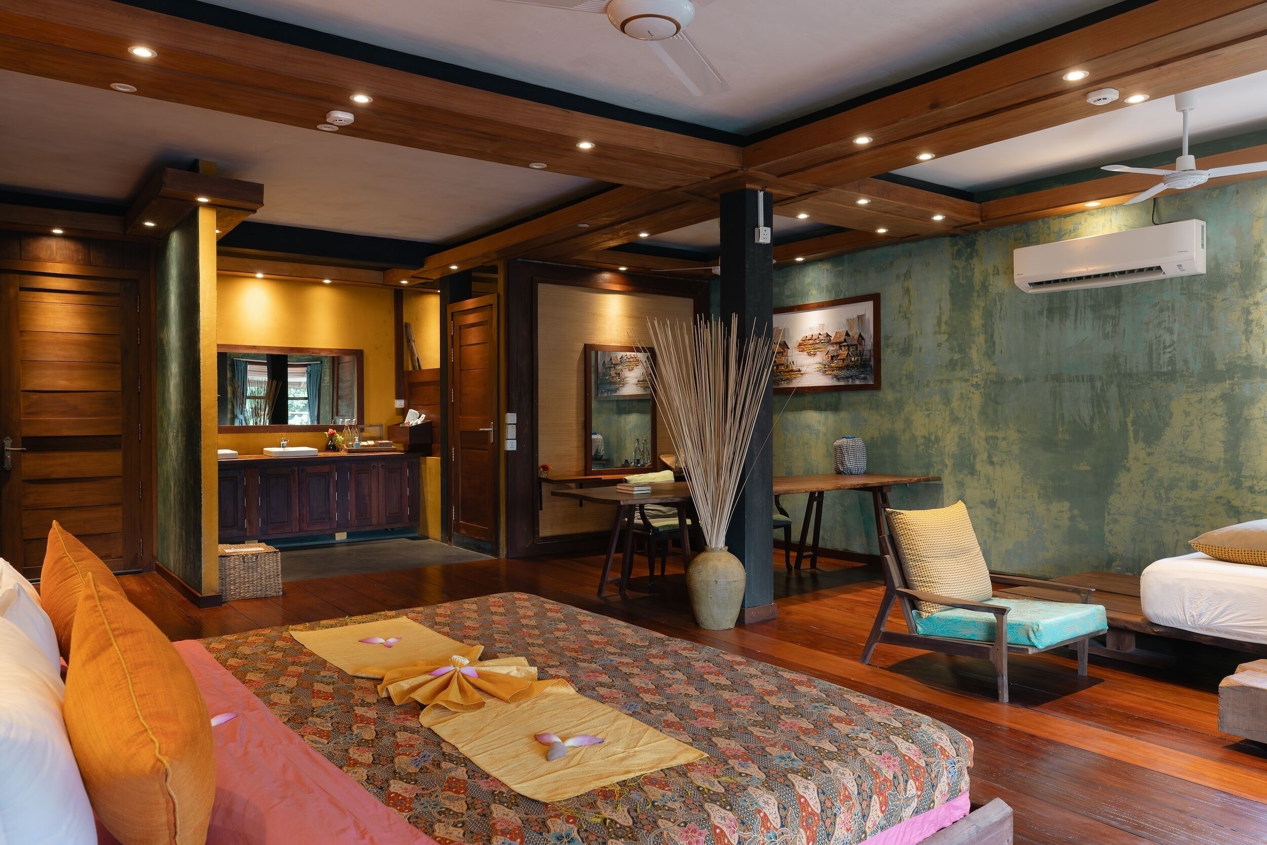 Una habitación de hotel con una cama grande, un escritorio, una silla y un área de comedor.
