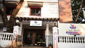 Un edificio con un letrero que indica 'Carnival Bar & Restaurant' y un número de contacto.