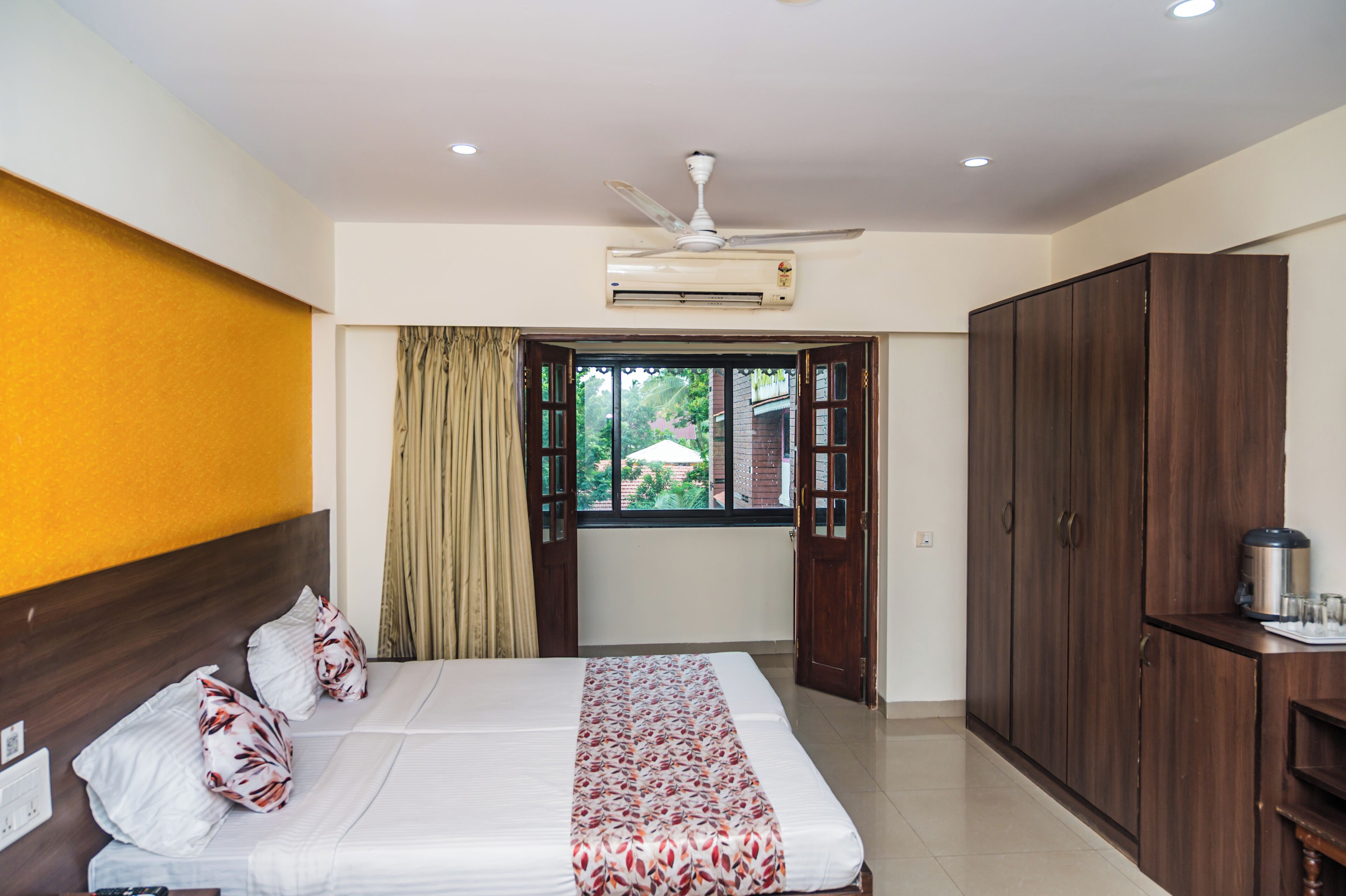Habitación de hotel con cama, armario y aire acondicionado.
