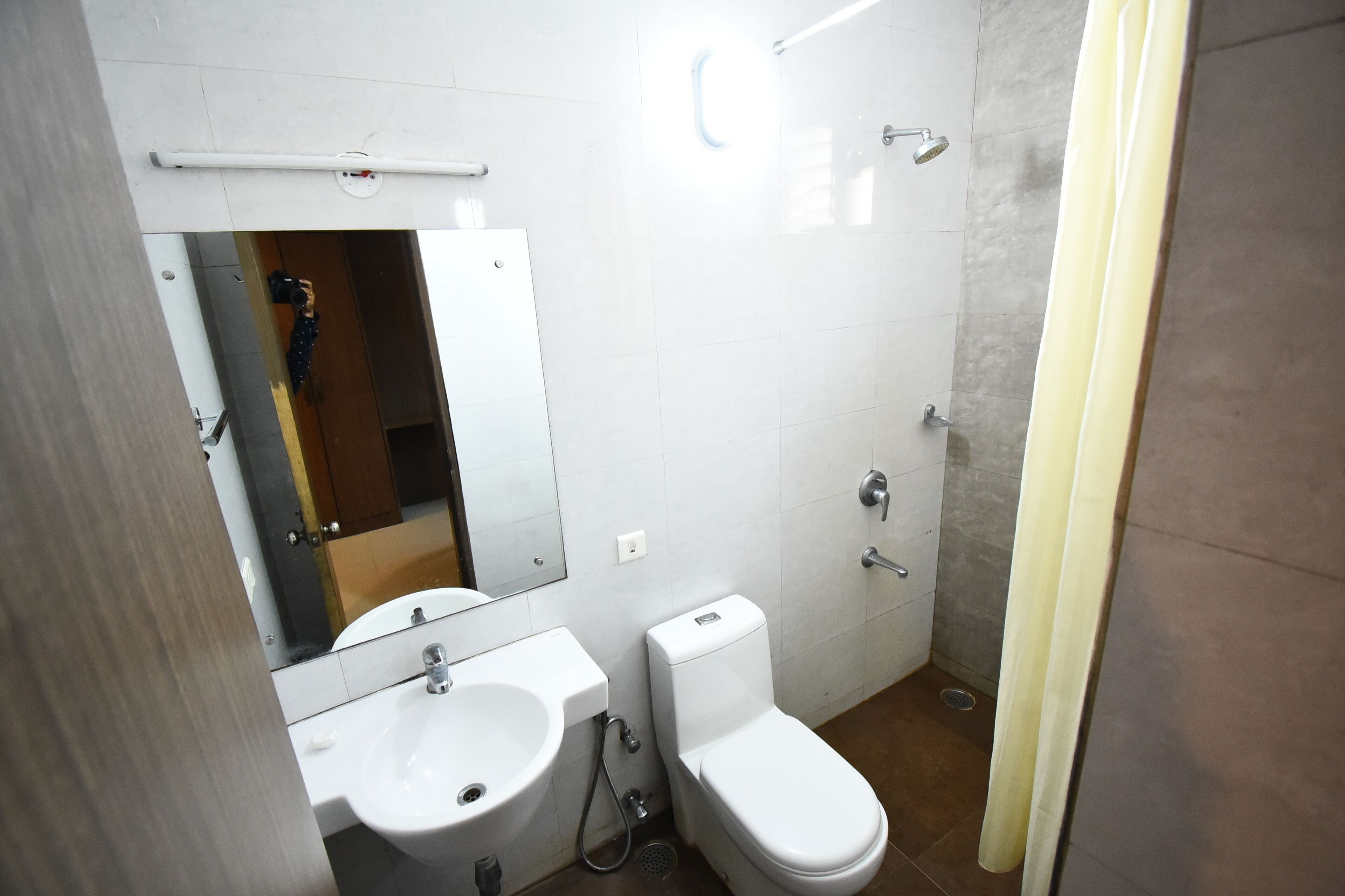 A bathroom with a sink, toilet, and mirror.