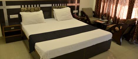 A neatly made bed with white linens, a wooden headboard with a cross design, and a brown chair with a striped cushion.