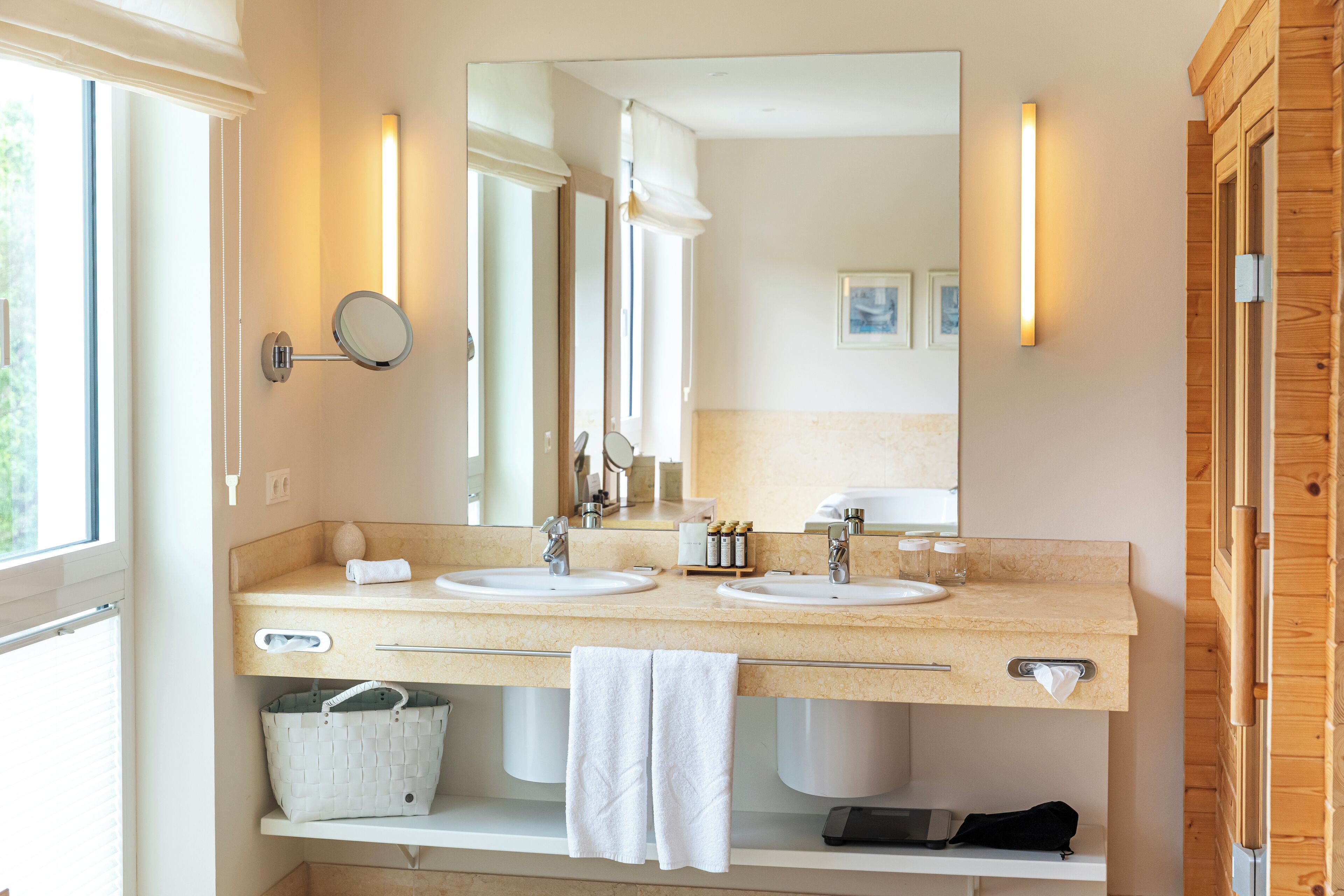 A bathroom with two sinks, a large mirror, and a wooden cabinet.