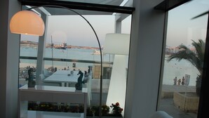 Ein modernes Interieur mit Meerblick, mit Essbereich, weißer Möbel und einer dekorativen Meerpferd-Figur.