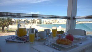 Ein Esstisch mit Blick auf Strand und Häuser.