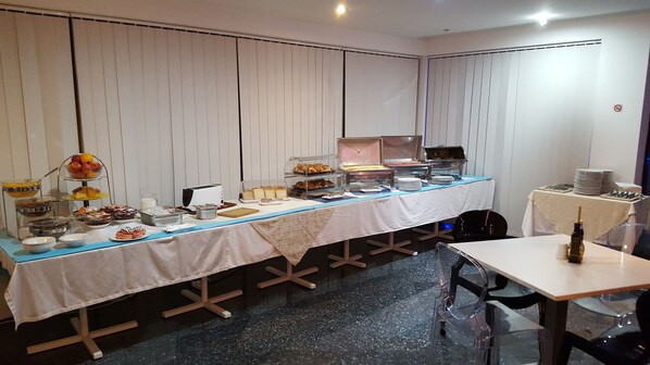 A buffet setup with various food items and a toaster.