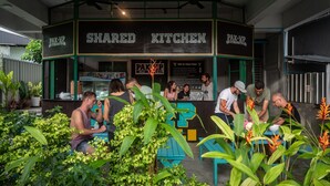 Een gemeenschappelijke keukenruimte met een bord waarop 'SHARED KITCHEN' en 'PAK-UP HOSTEL' staat.