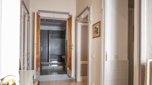 A hallway leading to a bathroom with a shower and toilet. - Stop & Sleep Bergamo (Bergamo)