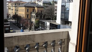 A balcony with a view of a cityscape, including buildings and a clear sky. - Stop & Sleep Bergamo (Bergamo)