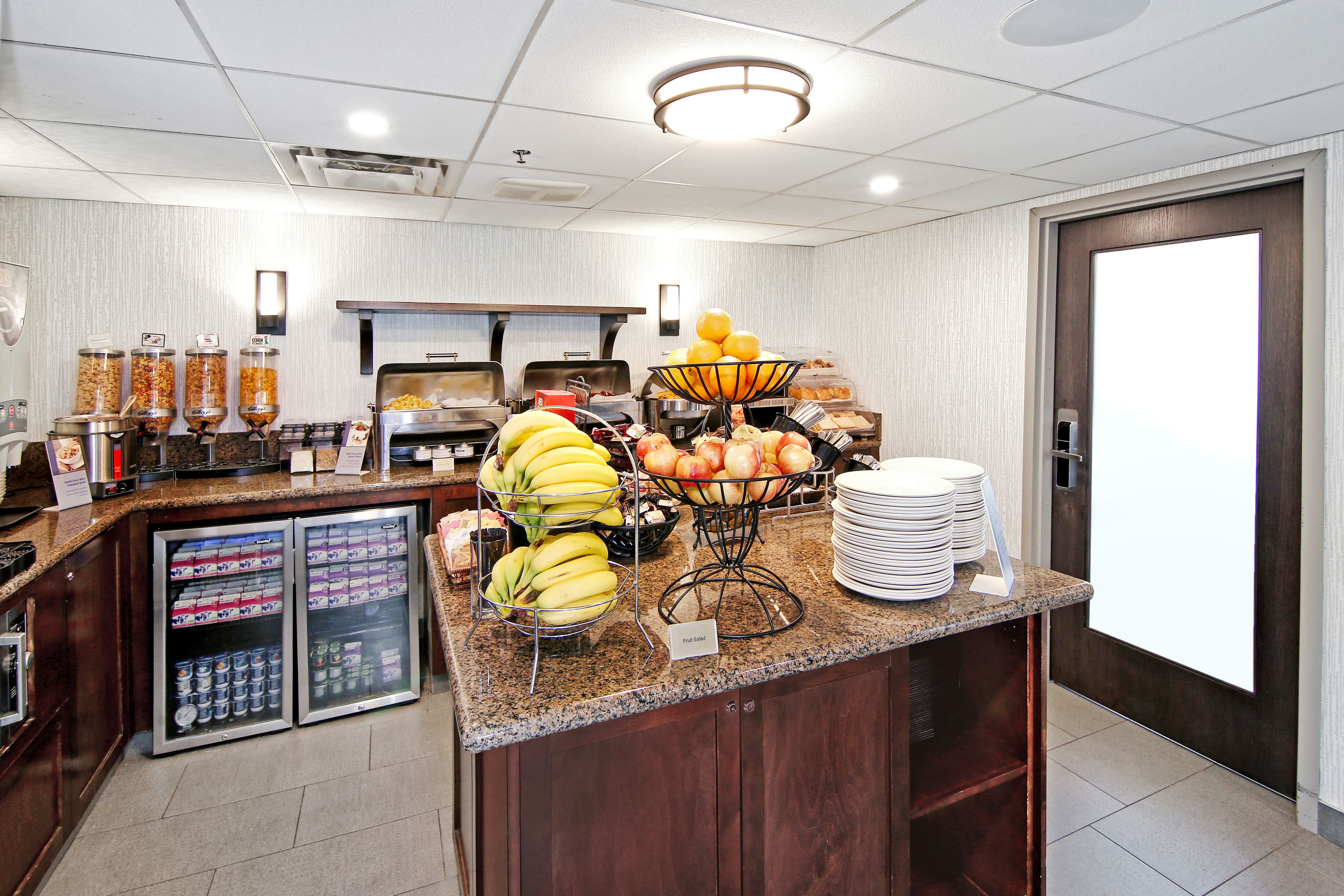 A buffet area with various food items, including fruits, vegetables, and beverages.