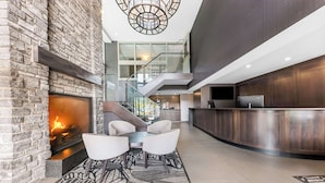 Un hall d’entrée moderne doté d’une cheminée, d’un coin salon et d’un comptoir de cuisine.