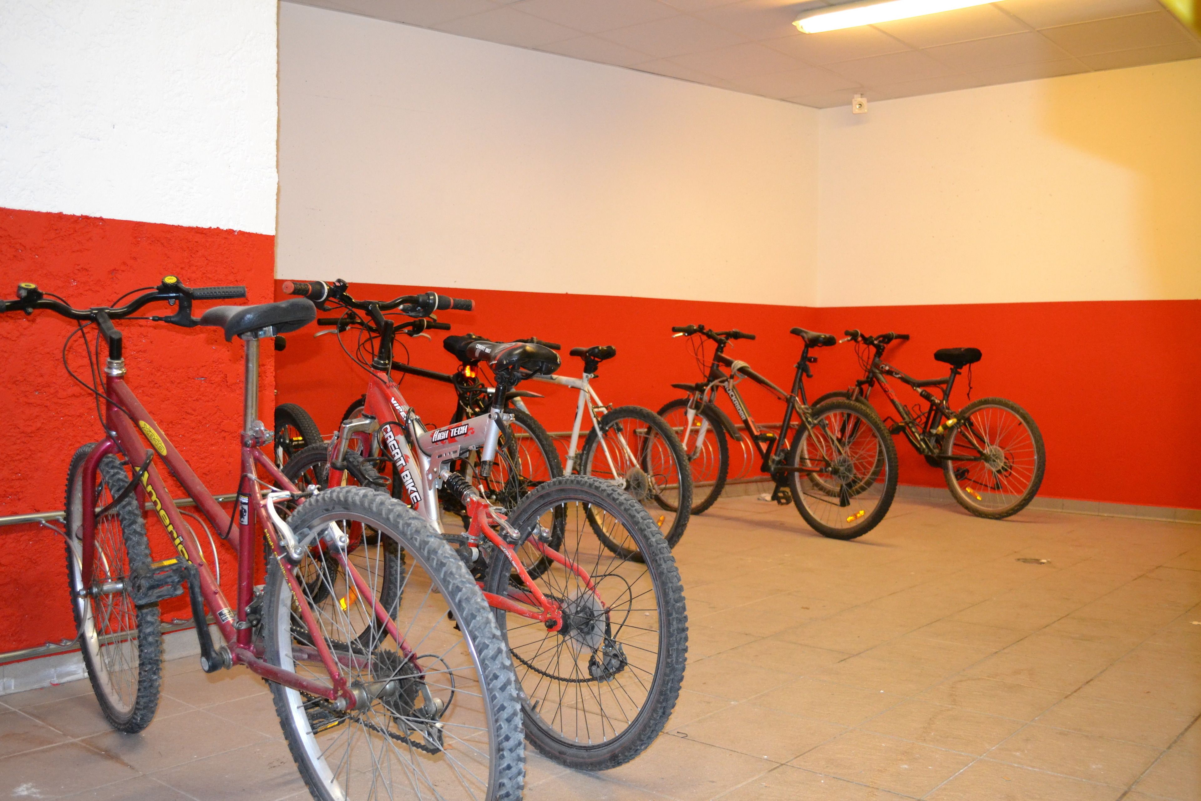 A row of bicycles parked against a wall with a red and white color scheme.