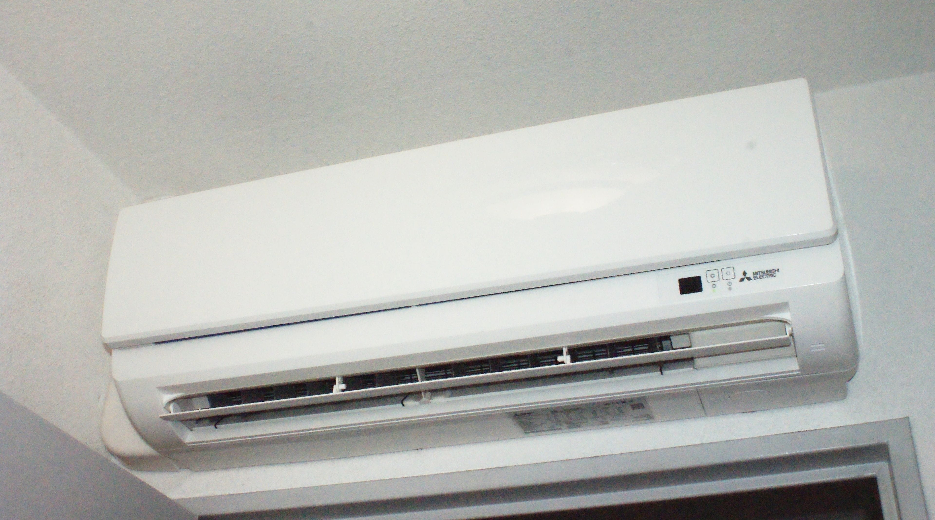 A white Mitsubishi electric air conditioner mounted on a wall.