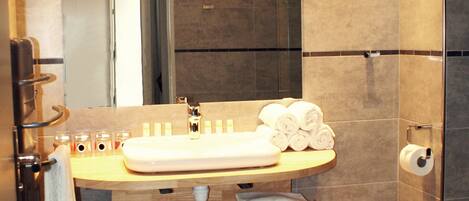 A modern bathroom with a large mirror, a sink, and a toilet.