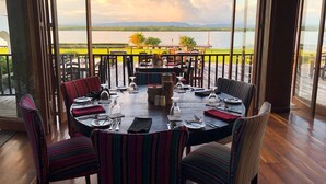A dining area with a view of a lake and mountains. - Umaya Resort & Adventures (Placencia)