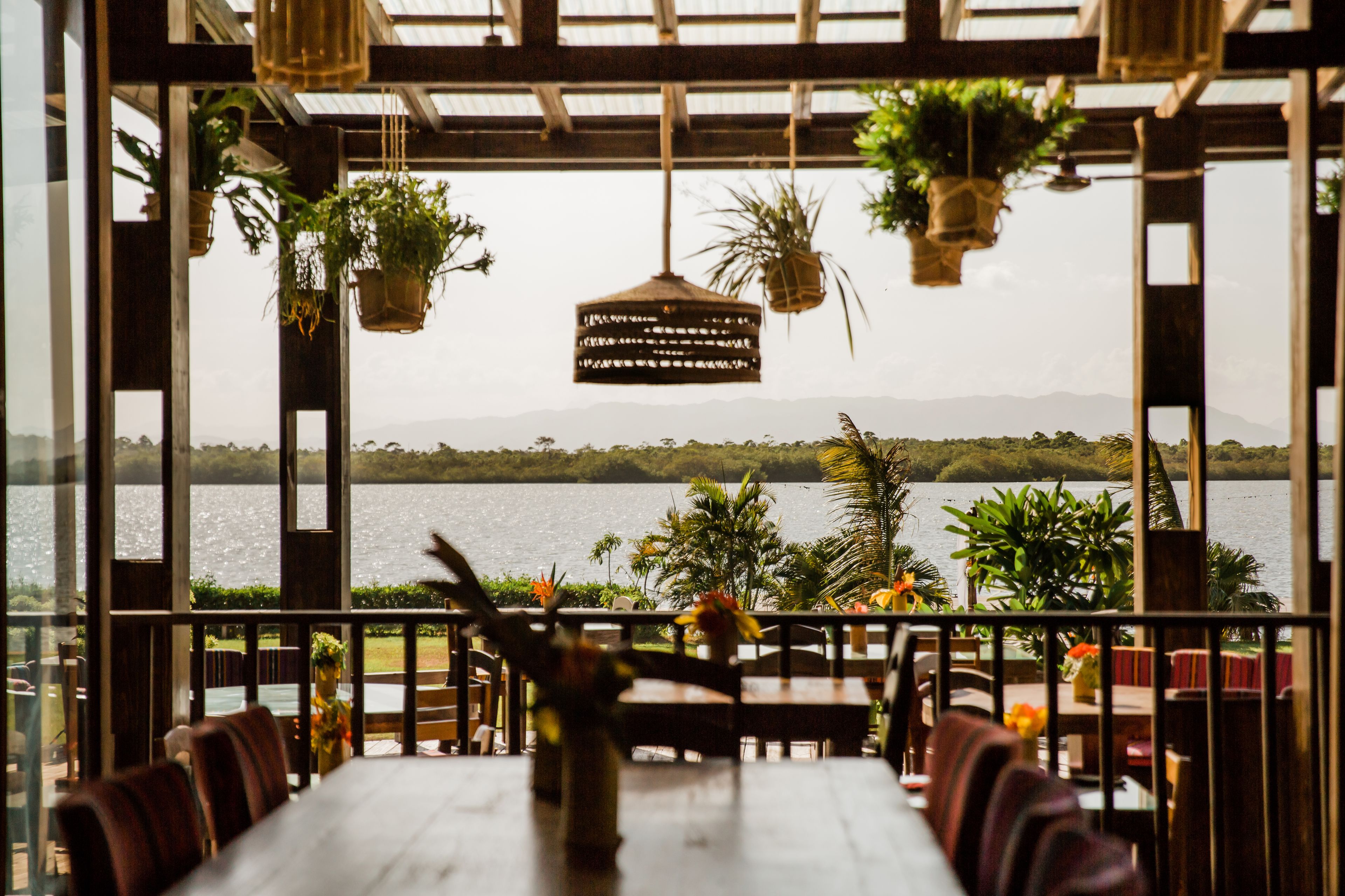 Un espacio de comedor al aire libre con vistas a un lago y montañas.