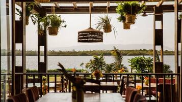 Un espacio de comedor al aire libre con vistas a un lago y montañas.