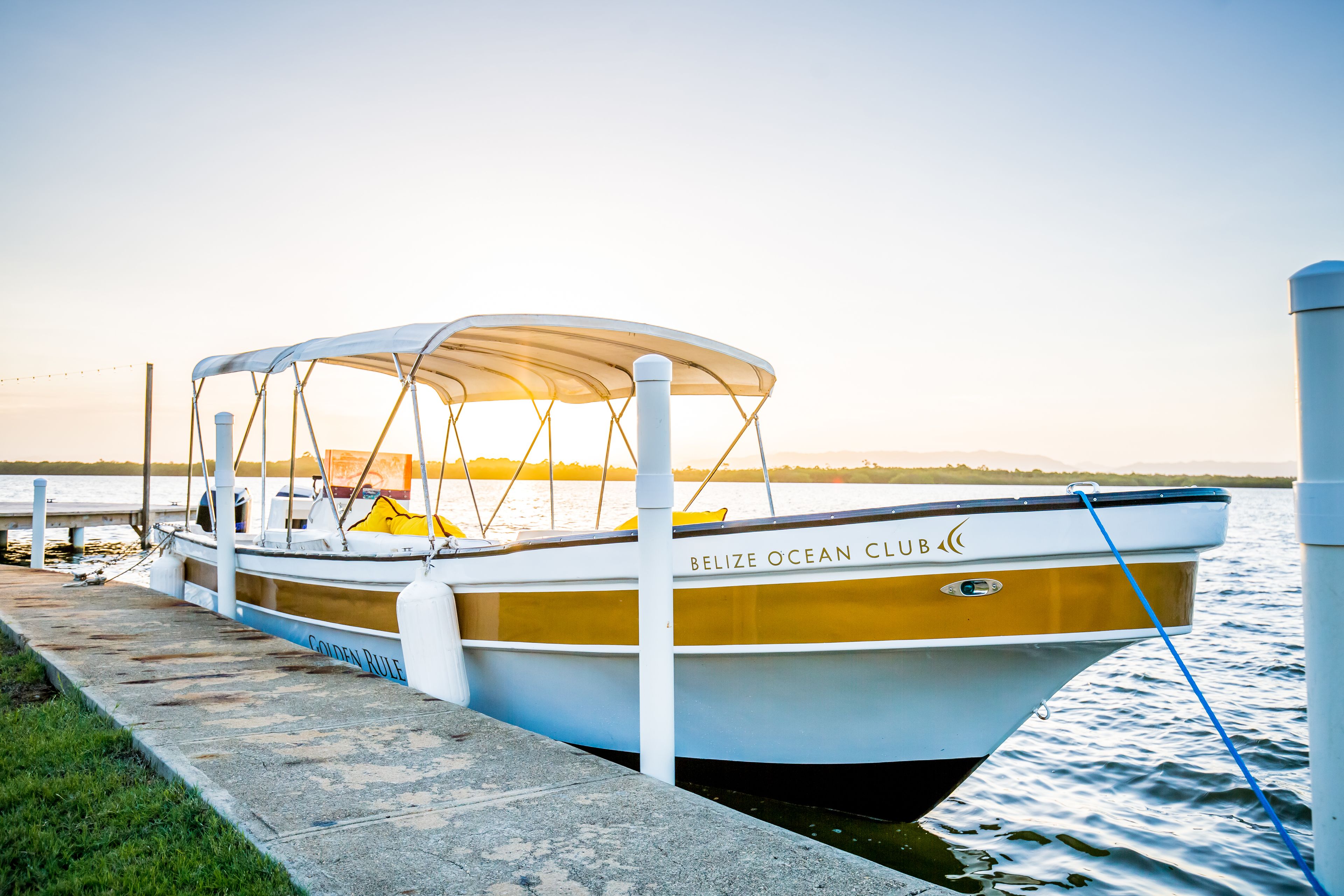 A boat docked at a pier with a clear sky in the background.