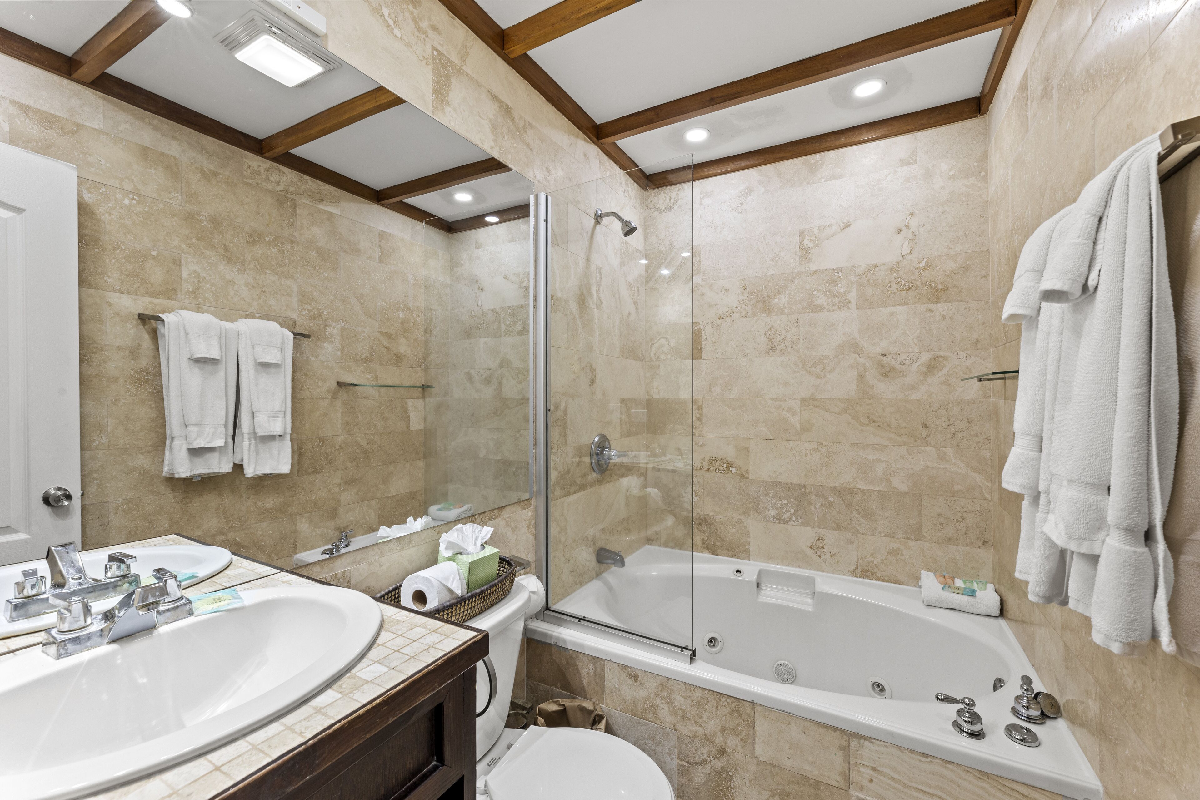 Un baño con una bañera grande, ducha y lavamanos.