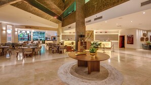 A spacious lobby with a central round table, multiple seating areas, and a restaurant named VETRI.