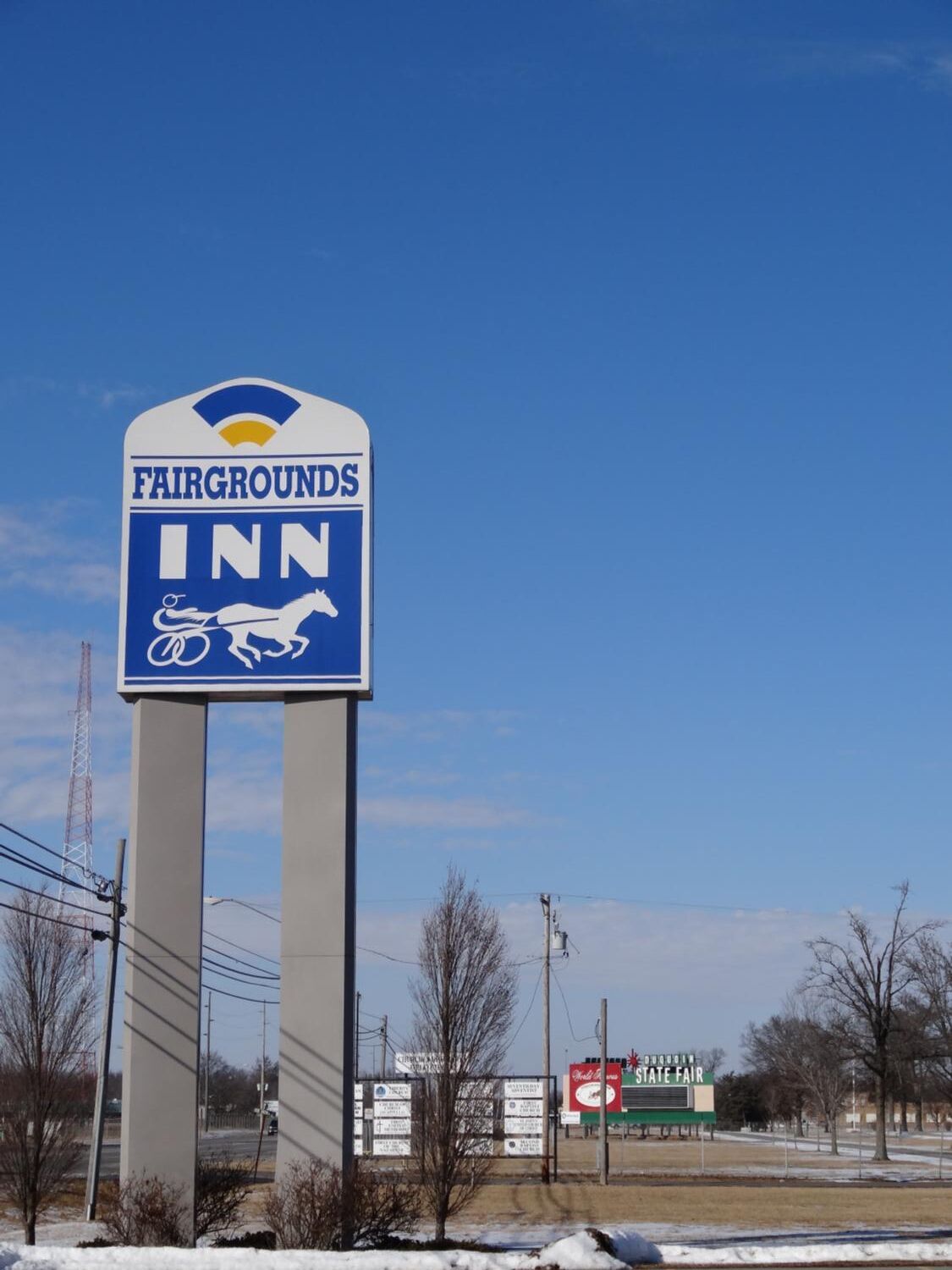A sign for Fairgrounds Inn with a horse and carriage symbol.