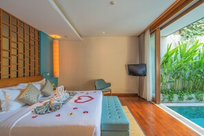 Un dormitorio con cama, televisión, silla y vista a una piscina.