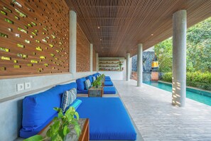 A covered outdoor seating area with blue cushions and a wooden slatted ceiling. - Maca Villas & Residence, Umalas (Kerobokan)