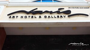 A sign for the Art Hotel & Gallery with a distinctive logo. - Naris Art Hotel (Pattaya)