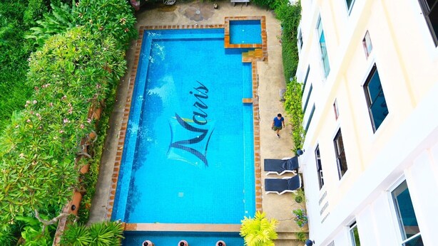 A rectangular swimming pool with a tiled border and a name 'Maris' in the center. - Naris Art Hotel (Pattaya)