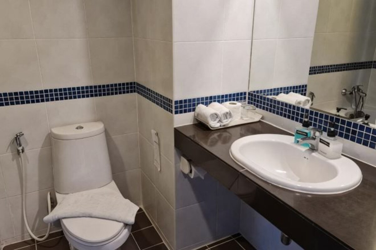 A bathroom with a toilet, sink, and towel.