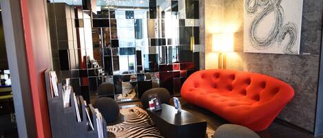 A modern interior with a red sofa, a zebra-patterned rug, and a glass partition.