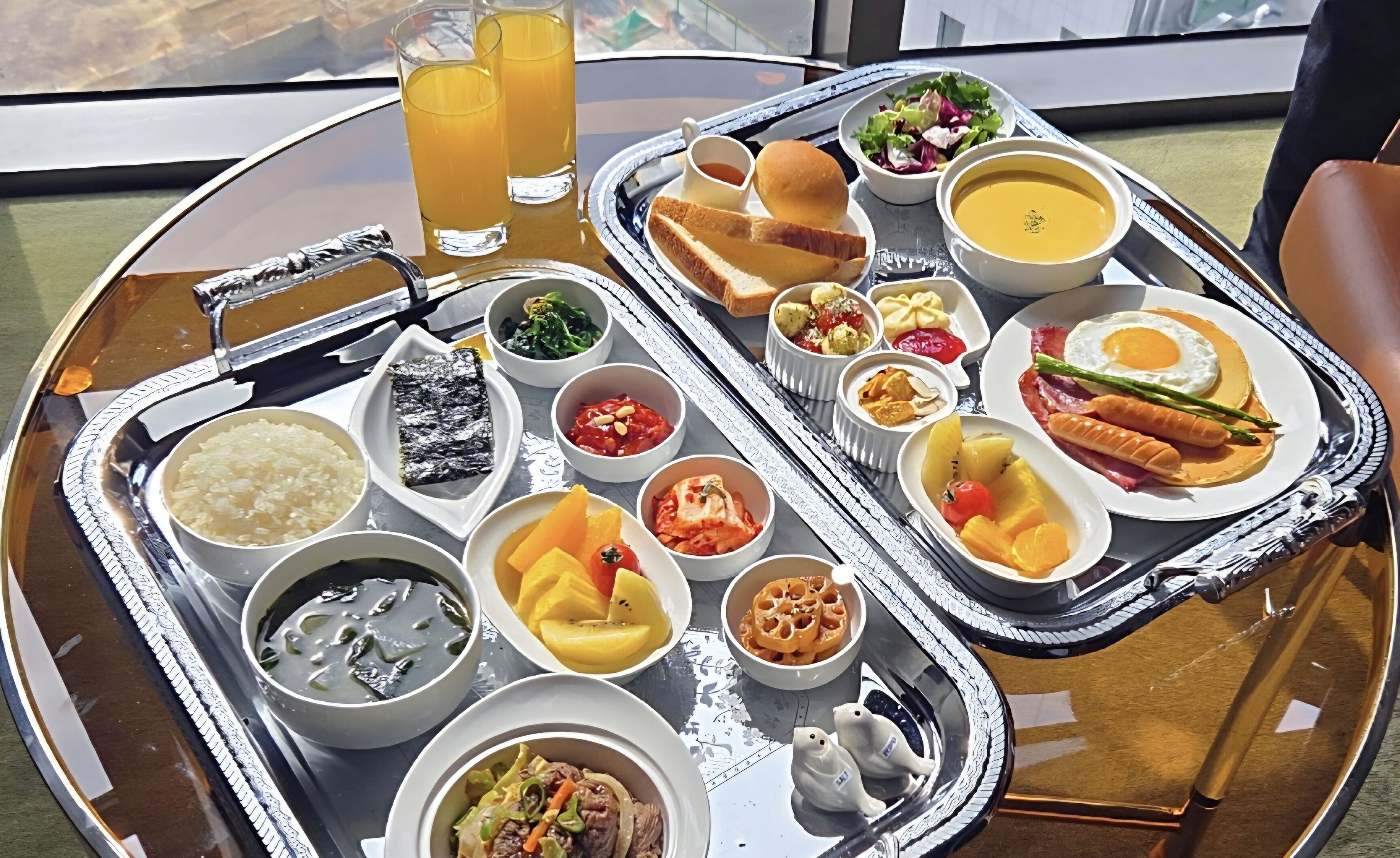 A variety of dishes on a tray, including soup, salad, and meat dishes.