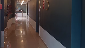 A corridor with a shiny tiled floor, a staircase, and a door with the number 5 on it. - K Hotel (Kuala Lumpur)
