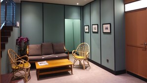 A modern living room with a sofa, two chairs, a coffee table, and framed pictures on the wall. - K Hotel (Kuala Lumpur)